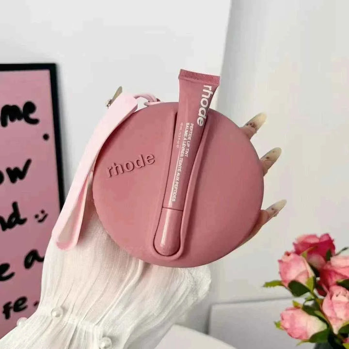 Rhode Peptide Lip Tint with matching round silicone pouch in pink, nourishing hydrating lip tint with soft color and sleek carrying case.