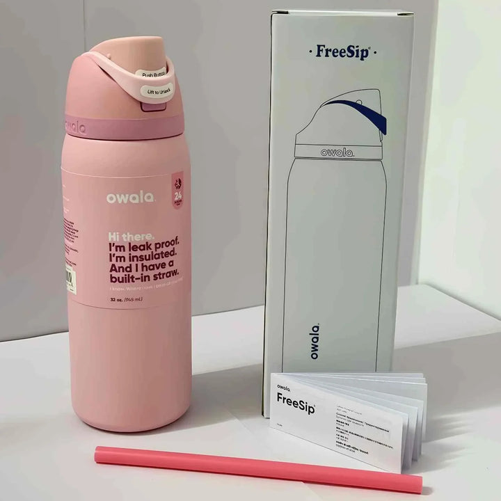 Pink Owala FreeSip insulated stainless steel water bottle with dual drinking spout, leak-proof design, and built-in straw, shown with packaging and user manual.