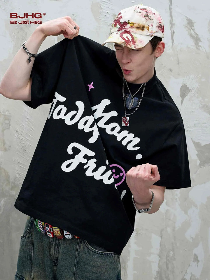 Young man wearing casual black printed t-shirt with "Mom Day is Friday" slogan and a smiley face.