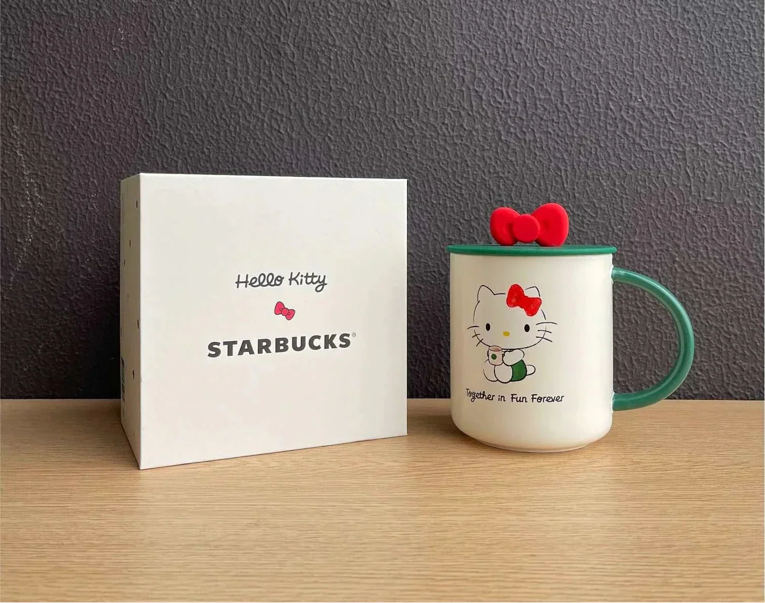 كوب Starbucks بتصميم Hello Kitty مع غطاء وقشة باللون الأخضر.