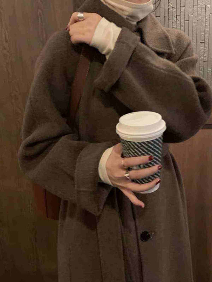 long luxurious winter coat made of high-quality goat wool in dark brown, with a stylish long cut and belt, perfect for elegant cold weather outfits