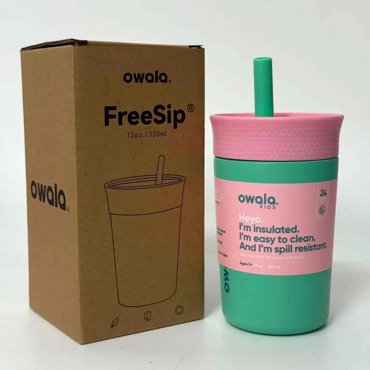 Owala FreeSip insulated kid's cup in green and pink with spill-resistant lid and straw next to its cardboard packaging box