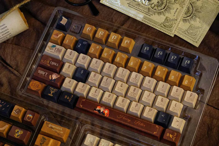 Harry Potter themed warm brown, cream, and dark blue mechanical keyboard keycaps with magical icons and characters, leather-like texture.