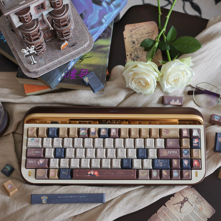 Harry Potter themed custom keyboard keycaps set with warm brown, cream, and dark blue colors featuring magical icons and characters, leather-like texture, displayed on a keyboard surrounded by books and white roses.