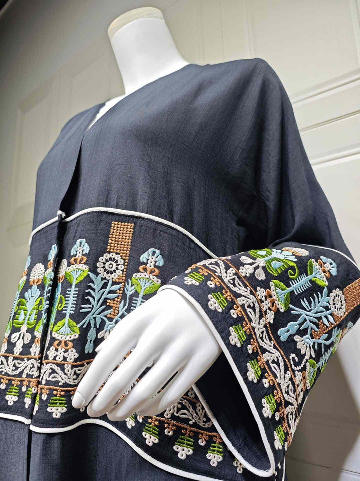 Elegant black abaya with modern traditional embroidery, wide sleeves and edges, perfect for a sophisticated look.