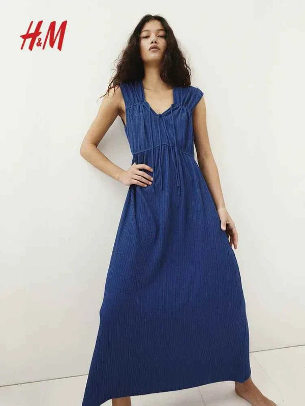إمرأة ترتدي ثوب أزرق ربيعي بموديل جديد من H&M.