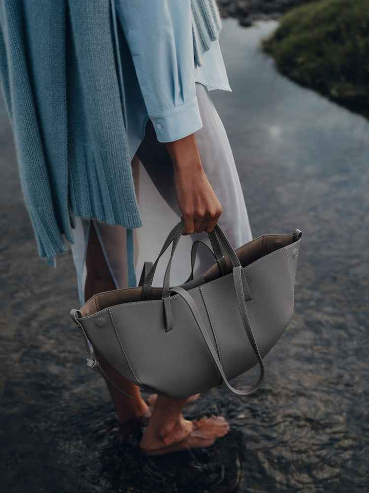 Polène Cyme Mini small gray leather tote bag with soft curves, dual-use open or closed design, handmade in Spain.