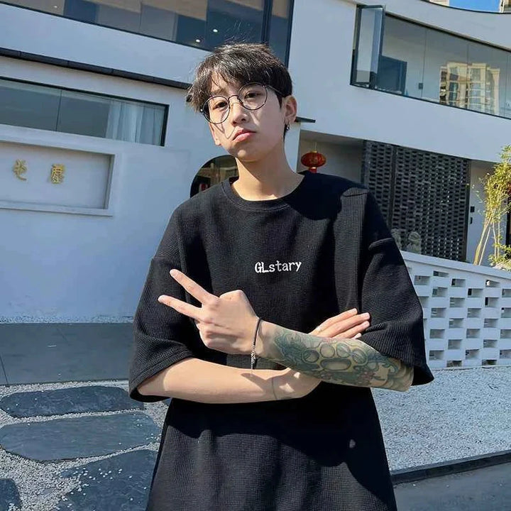 Black loose-fit تيشيرت MORRYING with cartoon character print worn by a young man outdoors