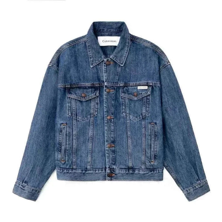 جاكيت جينز واسع من CALVIN KLEIN بتصميم كلاسيكي وأزرار برونزية وألوان أزرق متدرج أسود مع جيوب عملية