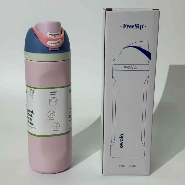 Owala FreeSip pink stainless steel water bottle with dual spout and leak-proof design next to its white packaging box