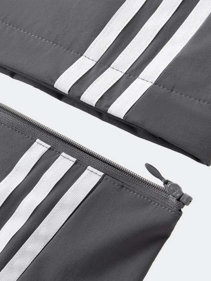 Adidas بنطال رياضي قابل للفصل رمادي مع خطوط بيضاء وسحّاب عند الركبة