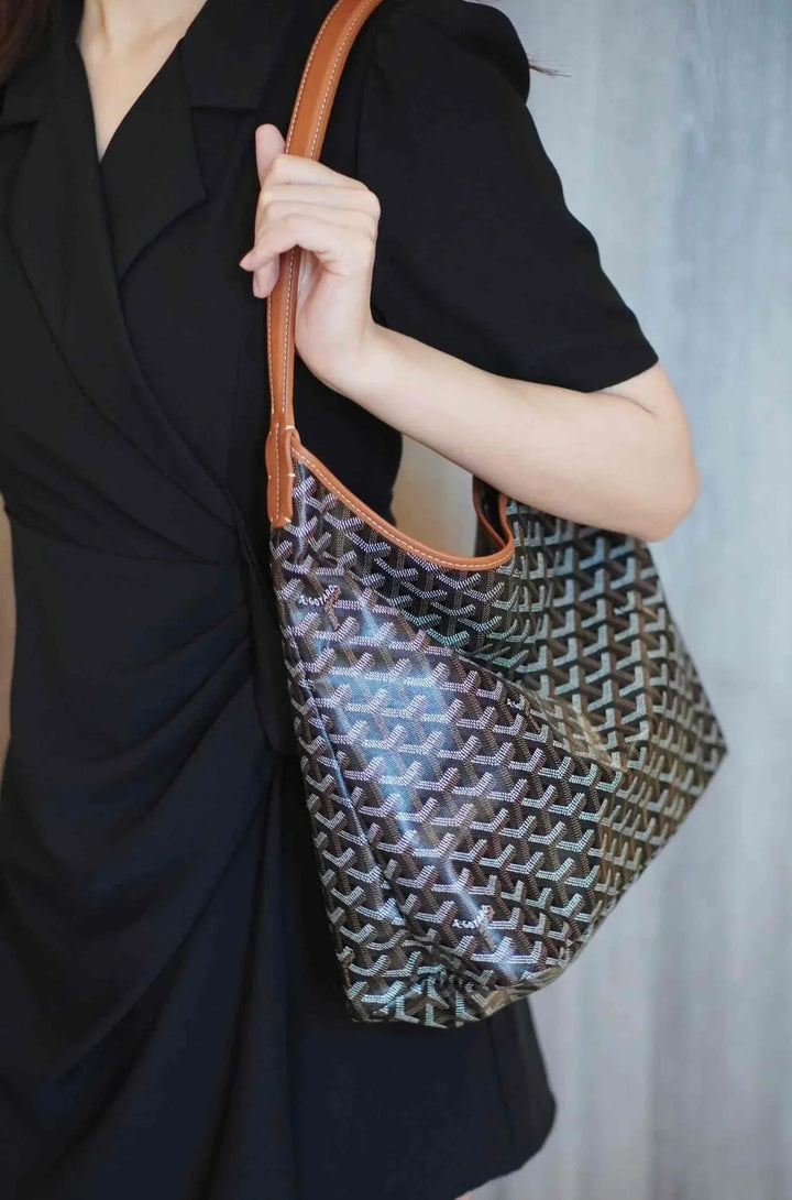 hobo bag حقيبة كتف with geometric luxury print and brown leather strap on woman wearing black dress