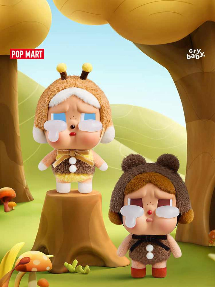 POP MART Crybaby plush dolls in bee and bear costumes, standing on tree stumps in a whimsical forest setting.