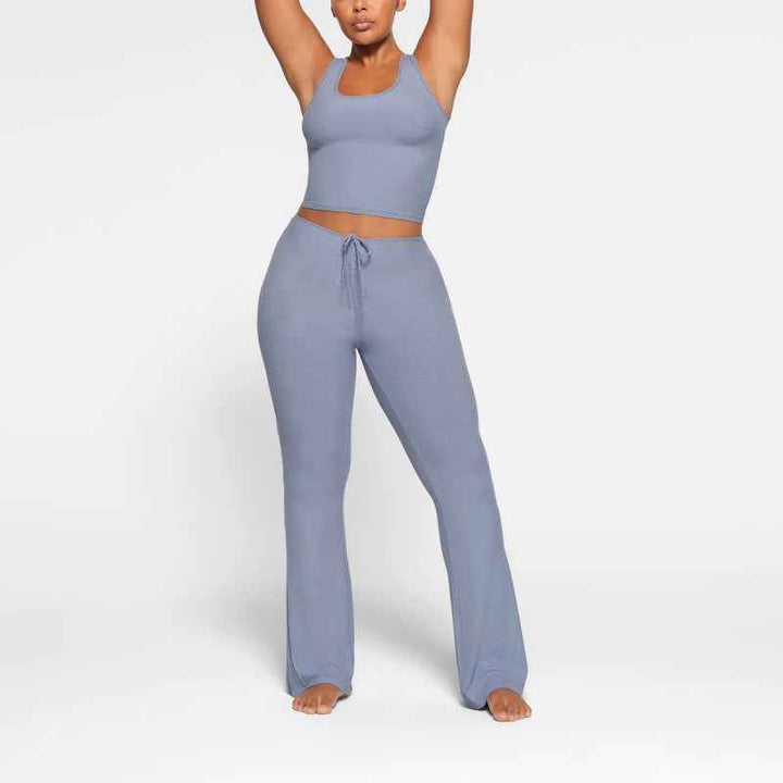 woman wearing light blue SKIMS wide leg lounge pants with adjustable drawstring waist and matching tank top