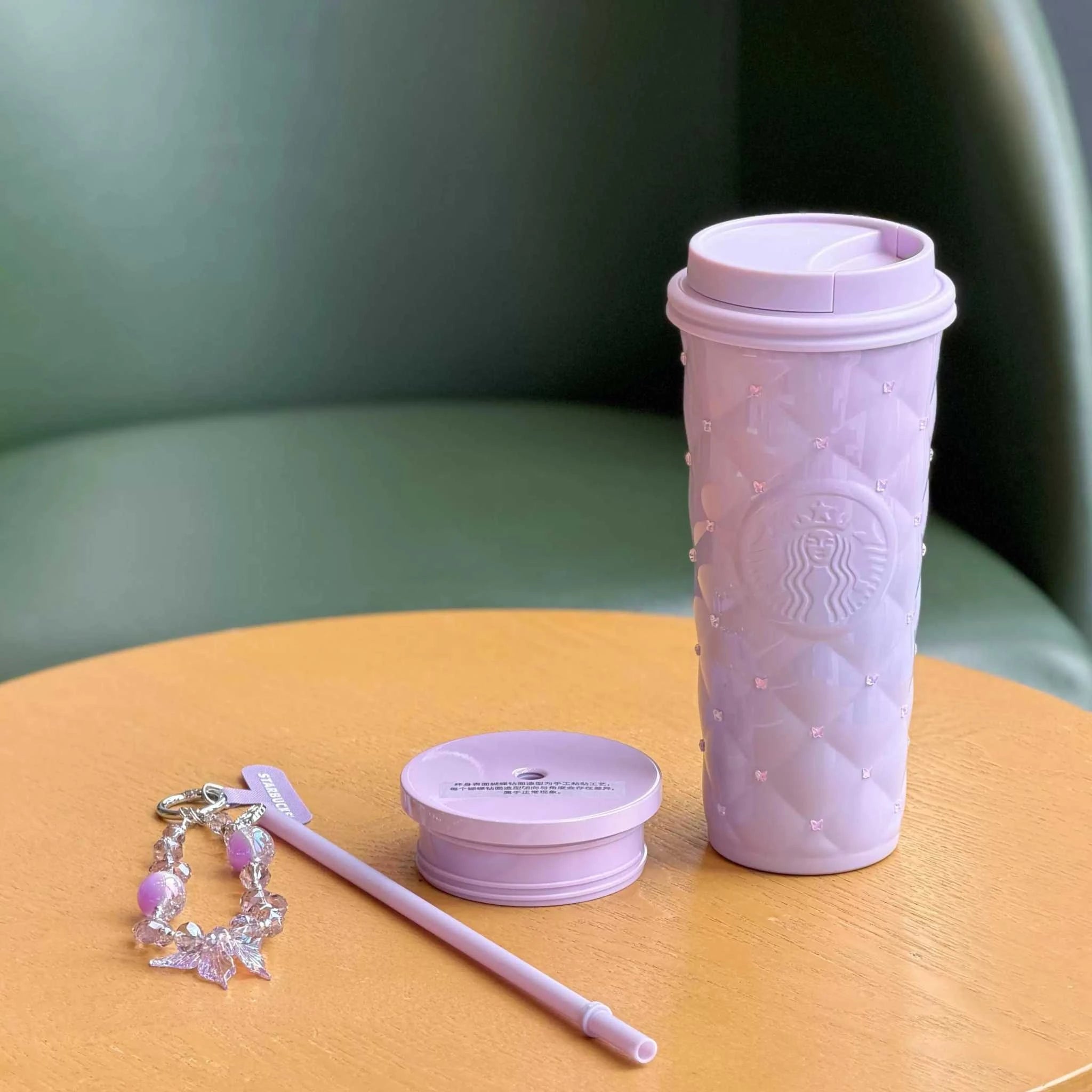 كوب Starbucks بنفسجي مرصع مع تعليقة أنيقة وغطاء إضافي.