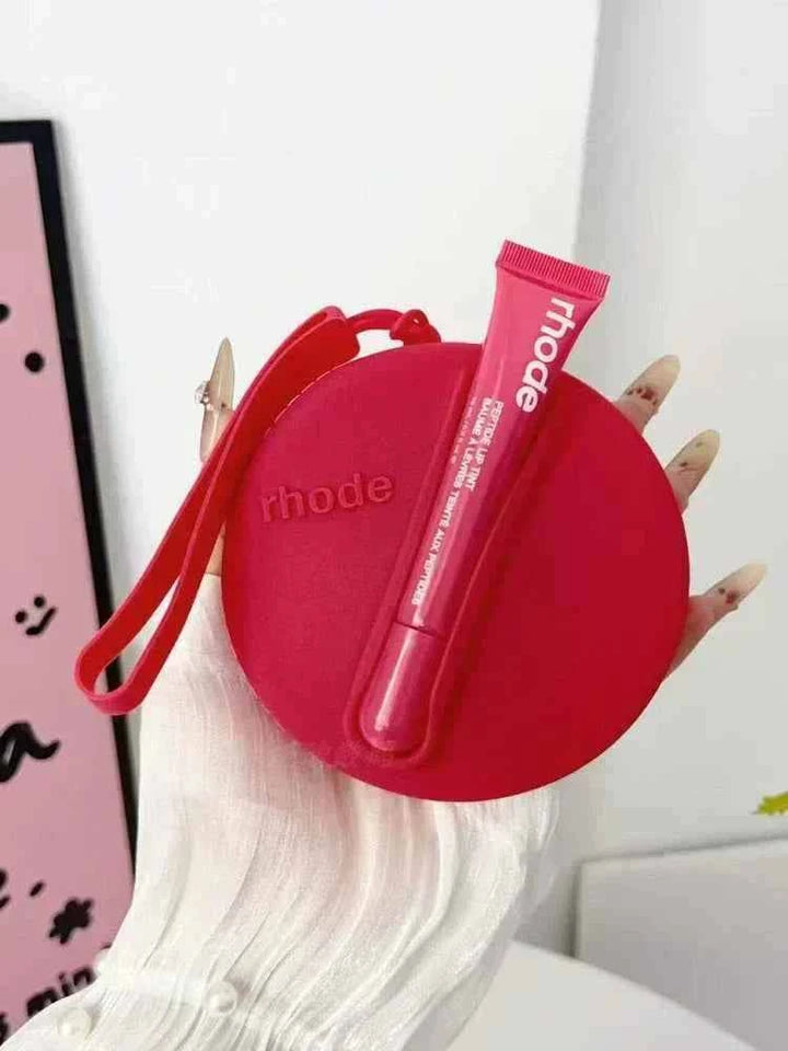 Rhode Peptide Lip Tint in red with matching round silicone pouch held by hand