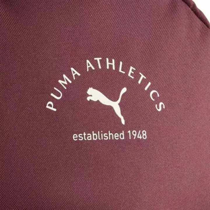 Close-up of burgundy PUMA Athletics backpack fabric with white logo and text established 1948