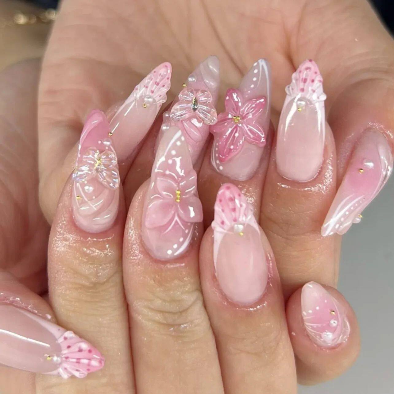 أظافر تركيب Press-on Nails بتصميم زهور بارزة وألوان وردية.