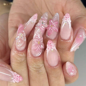 أظافر تركيب Press-on Nails بتصميم زهور بارزة وألوان وردية.