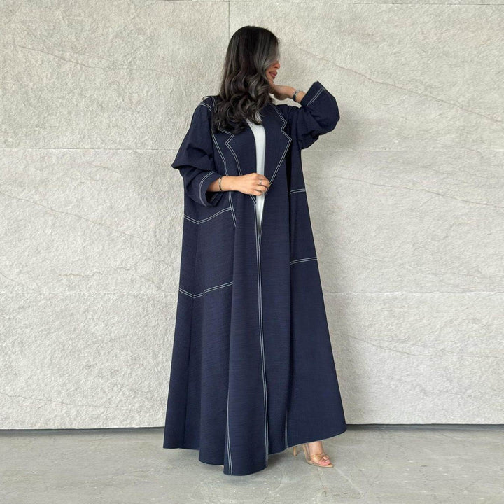 Dark navy wide abaya with elegant ruffles and visible stitching, featuring loose comfortable sleeves for a sophisticated look.