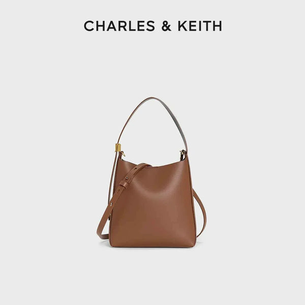 Brown small shoulder bag with matching wallet by CHARLES & KEITH, featuring gold-tone details and high-quality leather.