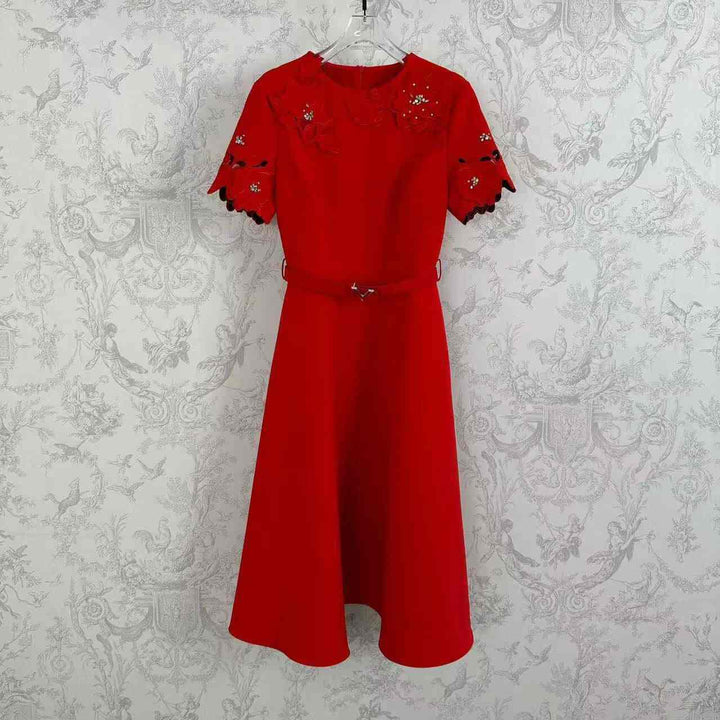 Elegant red floral dress with pearl and crystal embellishments, featuring lace sleeves and a metallic detailed waistbelt. Perfect for formal occasions.