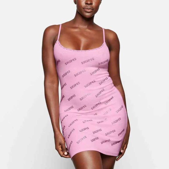 woman wearing pink Skims short dress with thin straps and logo print