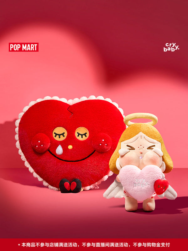 طقم هدايا Crybaby "Crying for Love" من Pop Mart يشمل دمية قطيفة بشخصية ملاك مع قلب وردي ووسادة قلبية مبتسمة.