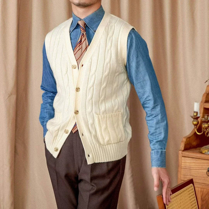 Mr. Lu San's wool cardigan vest in cream with cable knit, pearl buttons, and front pockets worn over blue shirt and tie.