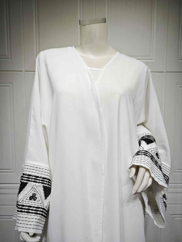 Elegant embroidered abaya with wide sleeves and geometric designs in classic colors.