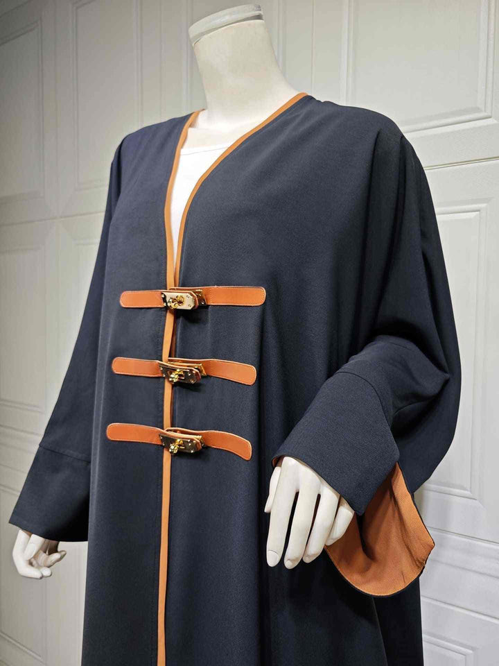 Modest fashion Abaya with leather straps, color-blocked design.