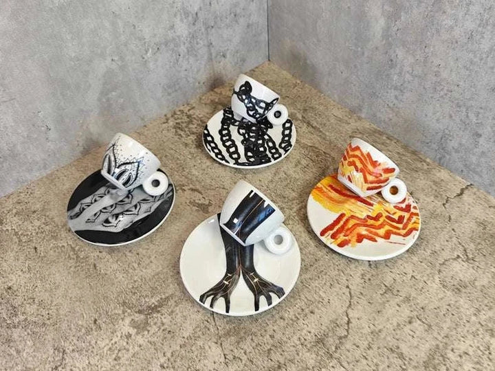 فناجين اسبريسو illy 2024 برسوم فنية بالألوان الأسود والأحمر والبرتقالي مع أطباق متناسقة من البورسلان اللامع