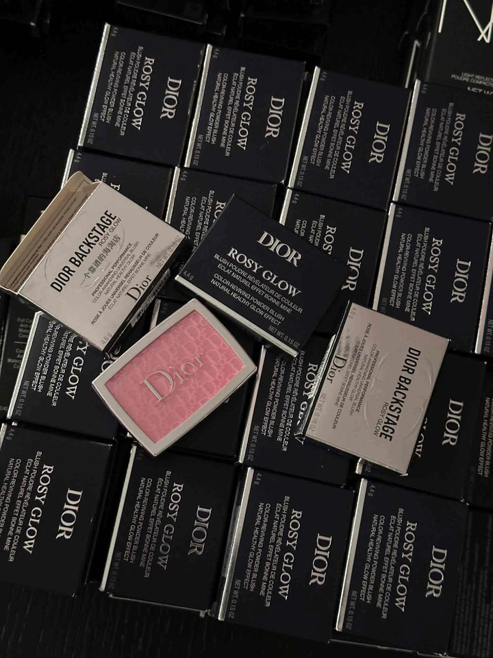 Dior ديور باكستيج أحمر خدود روزي جلو مرصوص بالتغليف الخارجي الأسود والمنتج الوردي في المنتصف. 