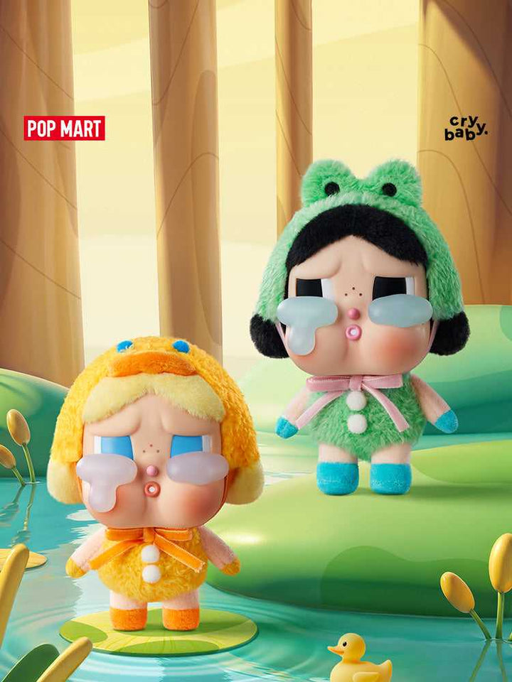 POP MART Crybaby plush toys in duck and frog costumes, displayed on a playful background.