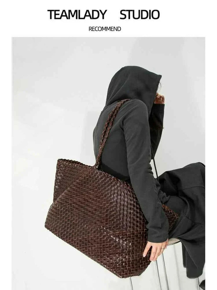 حقيبة توت كبيرةbrown large woven leather tote bag with shoulder strap on model wearing black hoodie and pants