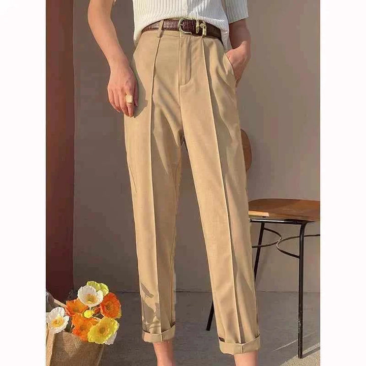 Beige classic cut formal women's pants made from luxurious fabric with a brown belt, styled for a comfortable and elegant look.