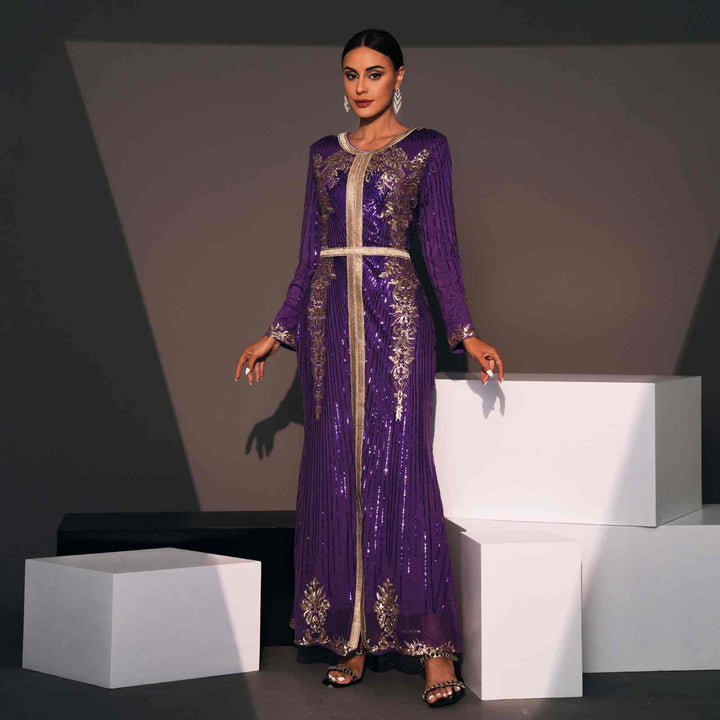 Elegant Moroccan kaftan in deep purple with gold embroidery and shimmering fabric, perfect for special occasions.