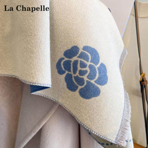 لقطة قريبة لزهرة زرقاء على زاوية الوجه الكريمي من شال La Chapelle الشتوي