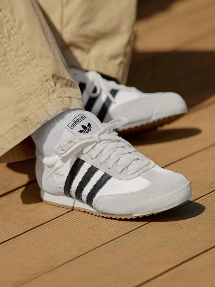 Adidas | أديداس حذاء R71 كلاسيك للجنسين أبيض مع خطوط سوداء بنعل مطاطي مسنن وتصميم ريترو كلاسيكي