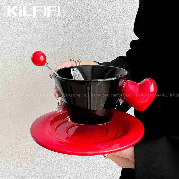 أطقم شاي سيراميك حب حمراء وسوداء مع ملعقة مزخرفة.