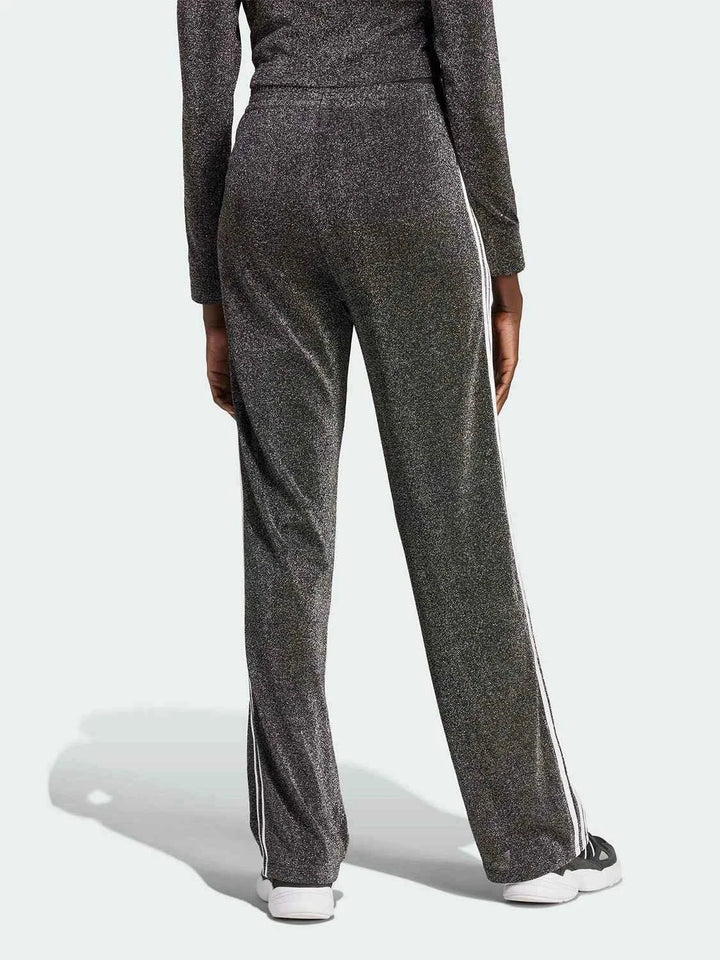 Shiny black Adidas pants with classic side stripes and a wide, comfortable fit for casual and athletic wear.
