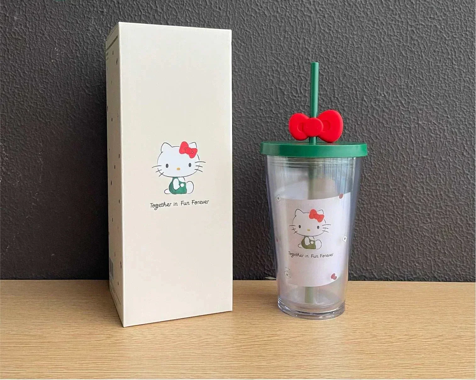 كوب Starbucks بتصميم Hello Kitty مع غطاء وقشة باللون الأخضر.