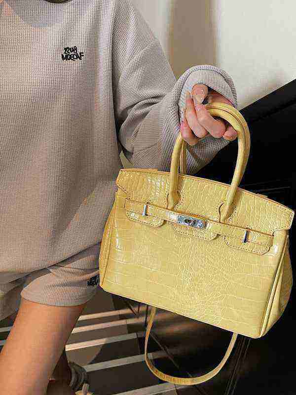 Yellow Birkin-style women's handbag with crocodile pattern and high-quality leather texture.