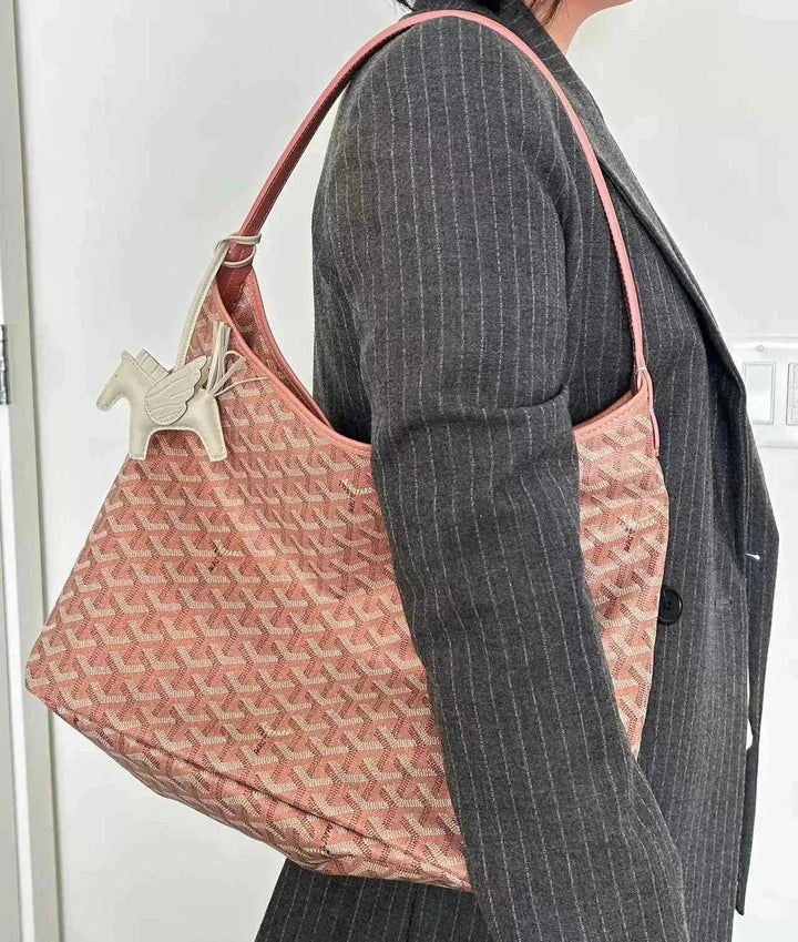 hobo bag حقيبة كتف مطبوعة بنقشة هندسية فاخرة مع حزام جلدي للكتف على ذراع امرأة ترتدي معطف رمادي
