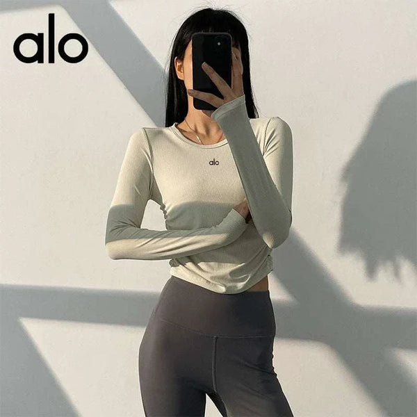 تيشرت أكمام طويلة alo clothing برقبة دائرية عالية المرونة وجفاف سريع بلون بيج فاتح وشعار صغير على الصدر