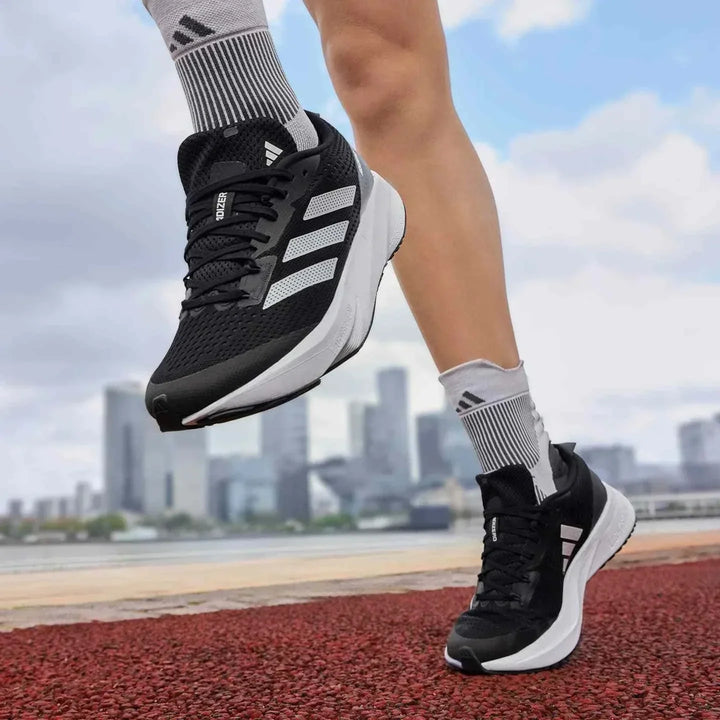 Adidas أديداس حذاء الجري السريع ADIZERO SL أسود بأحزمة بيضاء للرجال والنساء على مضمار جري المدينة