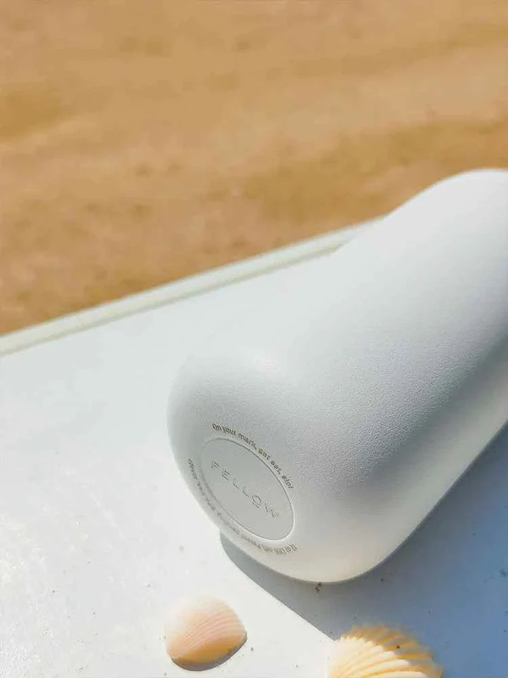 Fellow Carter insulated mug on a table, featuring a sleek white design.