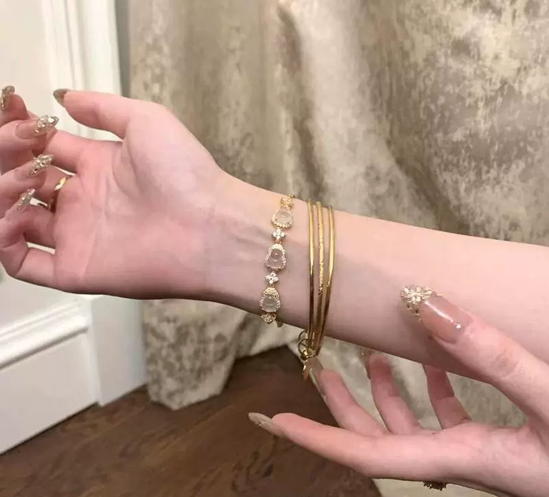 سوار نسائي ذهبي مرصع بأحجار الكريستال الأنيقة.