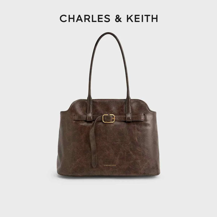 CHARLES&KEITH حقيبة كتف كبيرة من الجلد البني الداكن بحزام خصر وشعار معدني ذهبي تصميم أنيق ومتعدد الاستخدامات