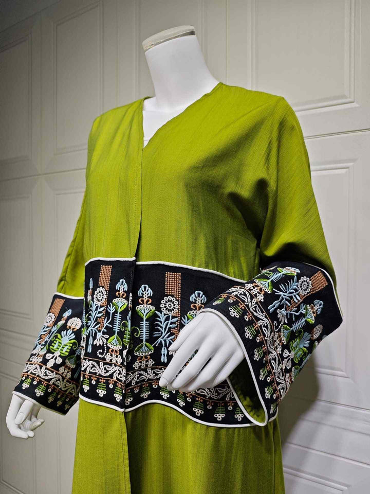 Elegant abaya with modern traditional embroidery, wide flowing design, in green.